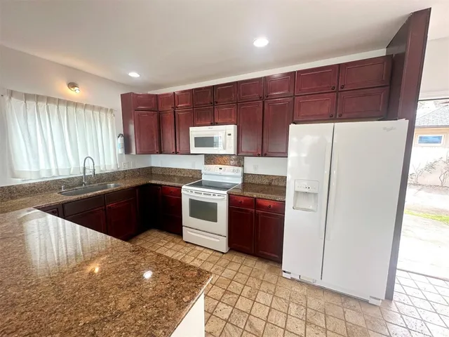 a kitchen with stainless steel appliances granite countertop a refrigerator sink and cabinets