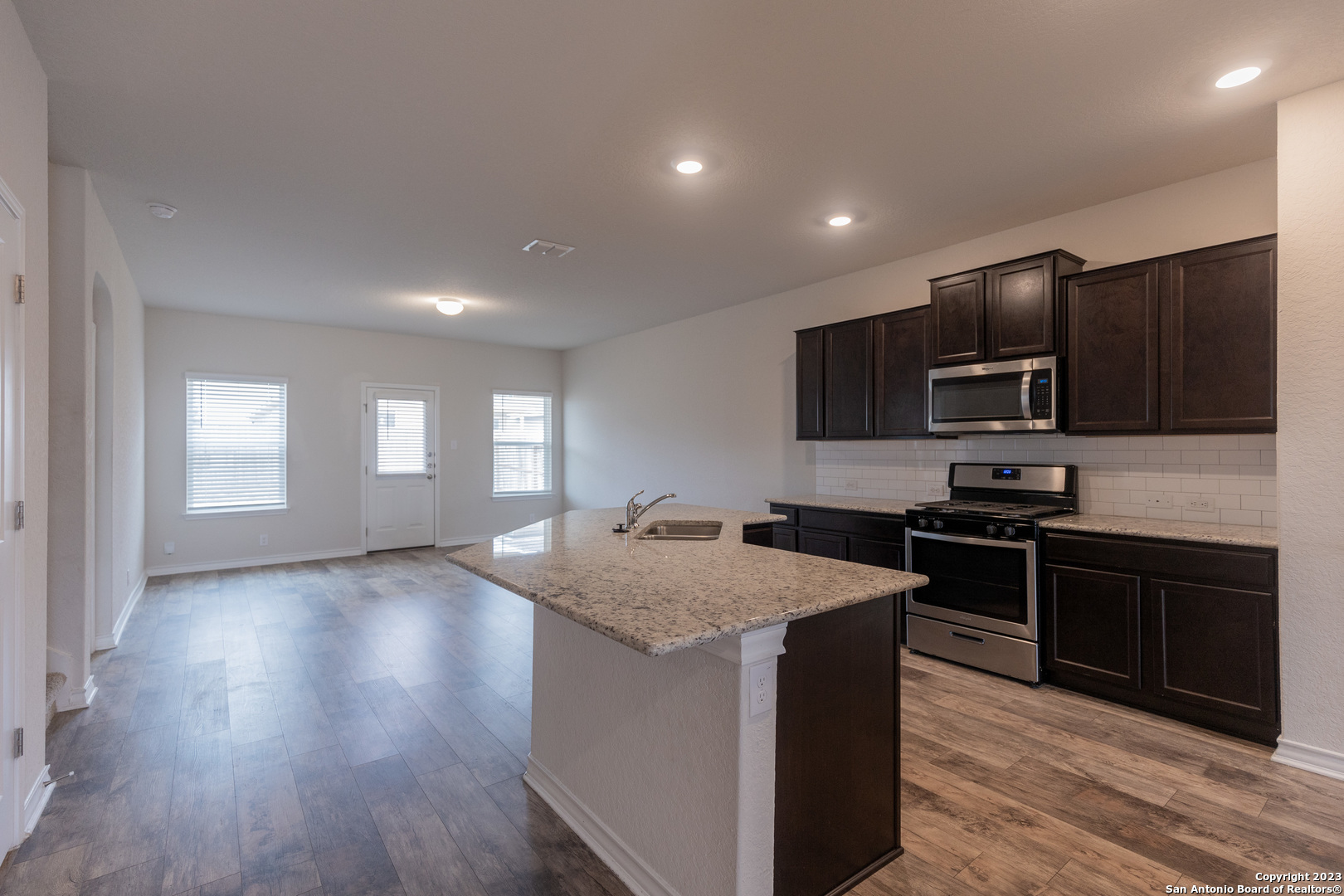 9819 Bratten Rise San Antonio, TX 78254 - Photo 6 of 37 a kitchen with stainless steel appliances granite countertop a stove a sink and a microwave