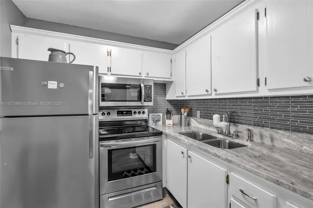 a kitchen with stainless steel appliances a refrigerator sink and microwave