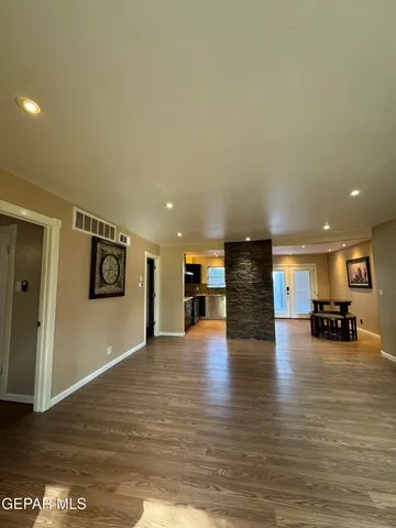 a view of a living room with kitchen island microwave and wooden floor