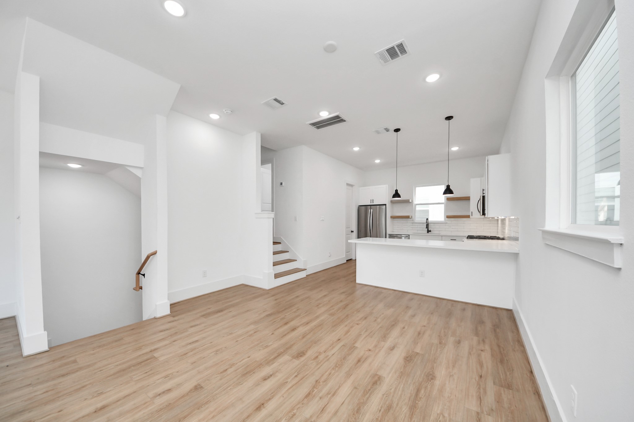 4806 Cochran Street Houston, TX 77009 - Photo 11 of 43 a large white kitchen with kitchen island a sink stainless steel appliances and cabinets