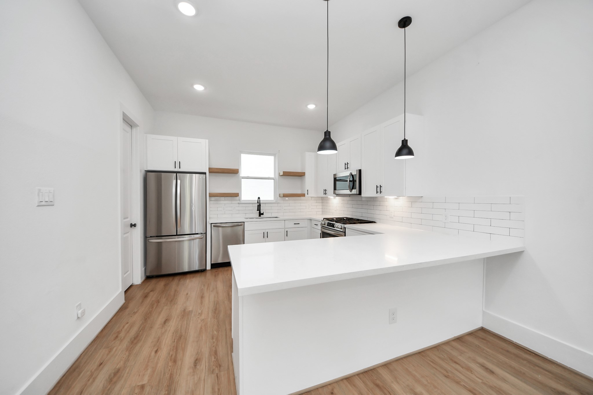 4806 Cochran Street Houston, TX 77009 - Photo 14 of 43 a kitchen with stainless steel appliances a sink a refrigerator a sink and wooden floor