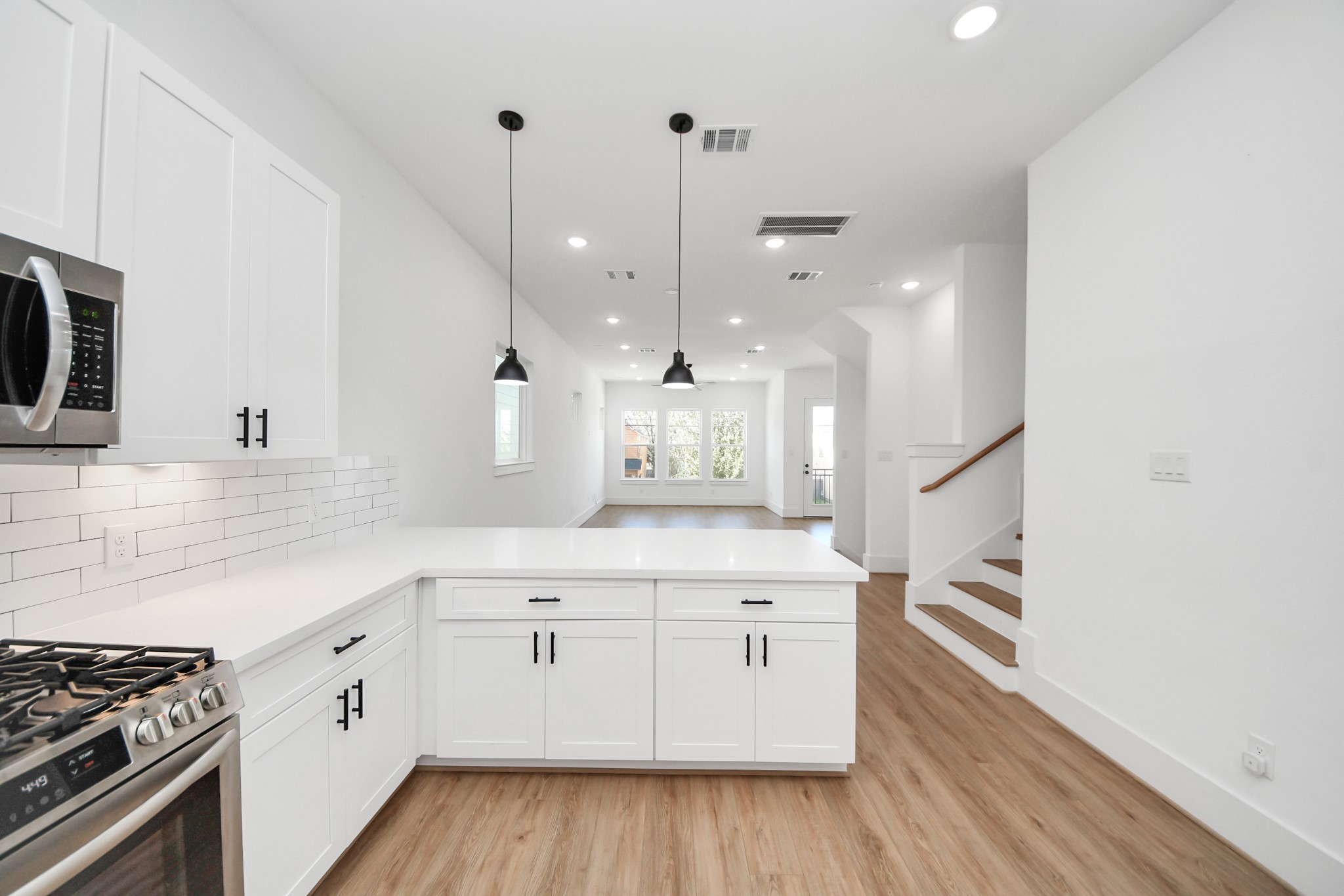 4806 Cochran Street Houston, TX 77009 - Photo 18 of 43 a kitchen with a stove a sink and wooden floor