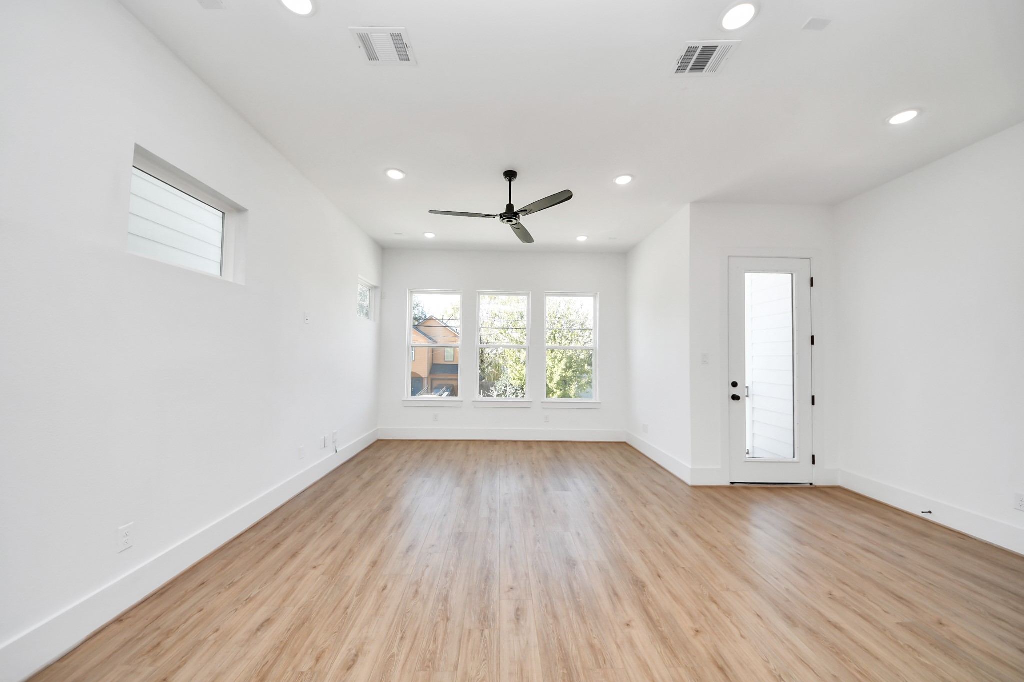 4806 Cochran Street Houston, TX 77009 - Photo 7 of 43 an empty room with wooden floor and windows