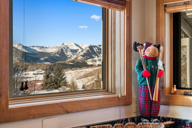 a view of a workspace with furniture and floor to ceiling window