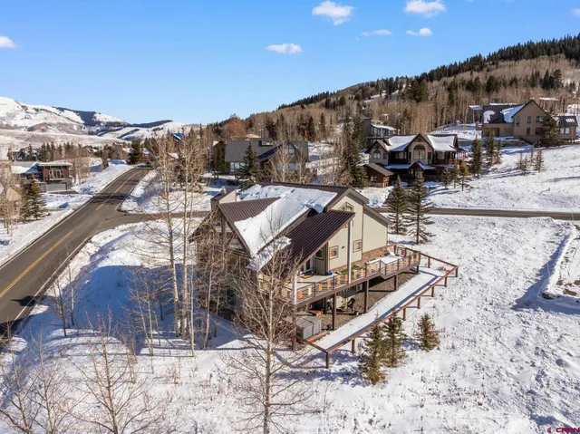 a view of a white building among the road and covered with snow in the background