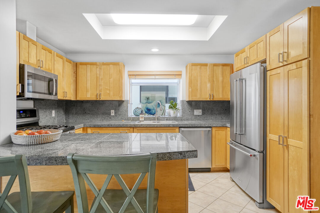 120 Fleet Street, Unit B Marina del Rey, CA 90292 - Photo 13 of 32 a kitchen with stainless steel appliances granite countertop a refrigerator a stove a sink and a microwave