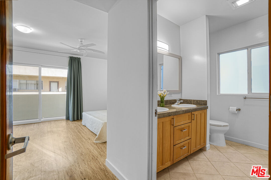 120 Fleet Street, Unit B Marina del Rey, CA 90292 - Photo 25 of 32 a bathroom with a granite countertop sink toilet and mirror