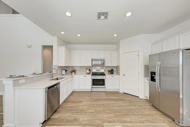 a kitchen with stainless steel appliances granite countertop a refrigerator and a stove top oven