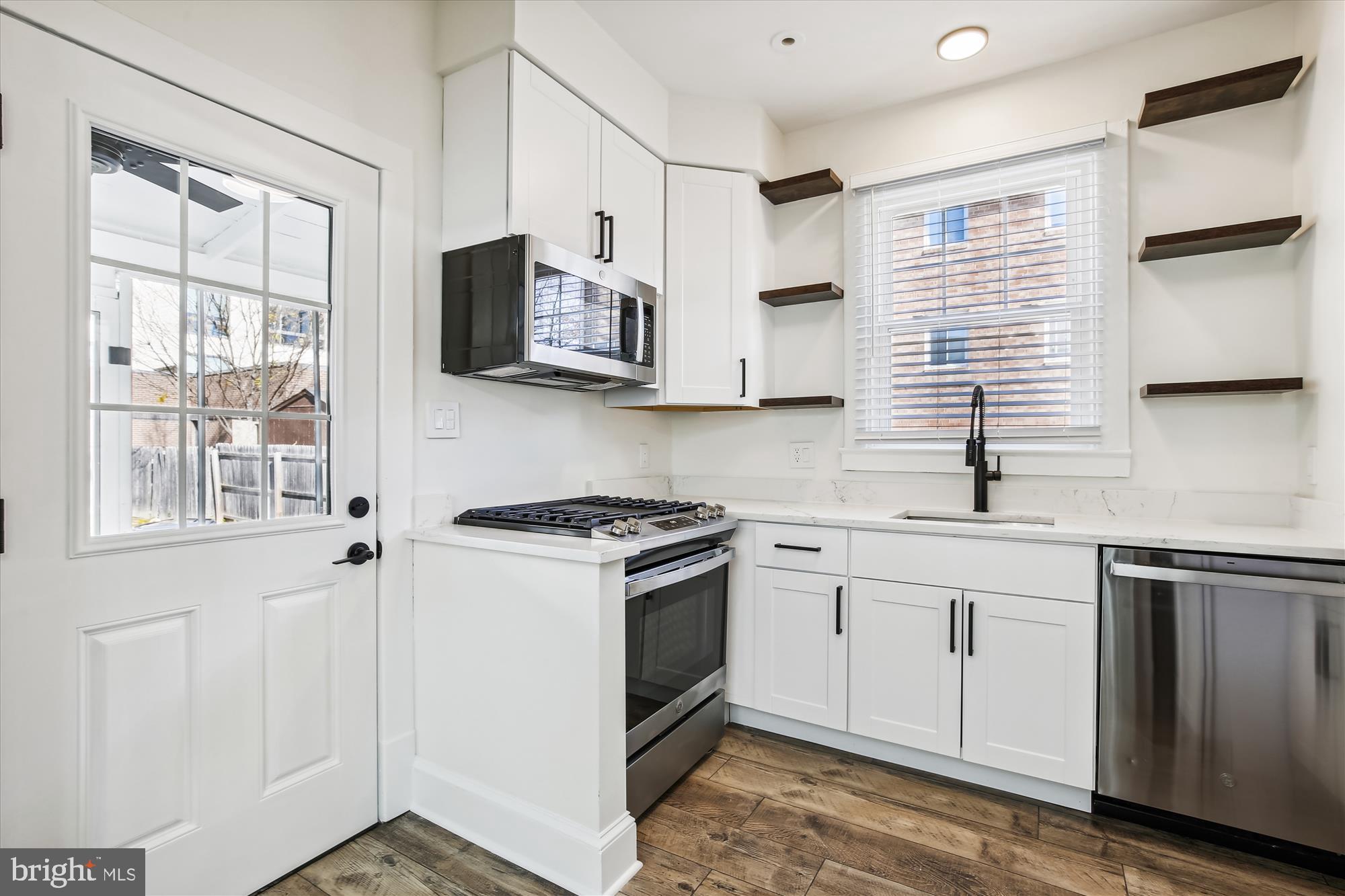 3107 9th Road North Arlington, VA 22201 - Photo 18 of 34 a kitchen with stainless steel appliances granite countertop white cabinets and window
