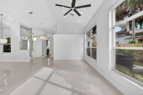 a view of a hallway with a dining table chairs and a refrigerator