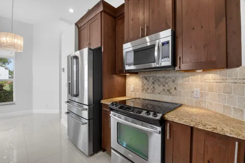 a kitchen with stainless steel appliances granite countertop a stove microwave and refrigerator