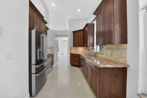 a kitchen with stainless steel appliances granite countertop a refrigerator and a sink