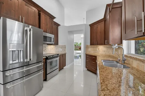 a kitchen with stainless steel appliances granite countertop a refrigerator sink and stove
