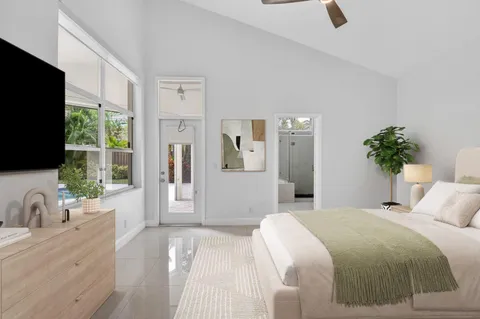 a bedroom with a large bed and a flat tv screen