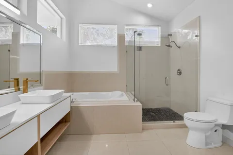 a bathroom with a sink a toilet and shower