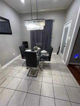 a living room with a dining table and a chandelier