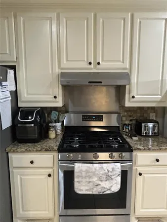 a stove top oven sitting inside of a kitchen