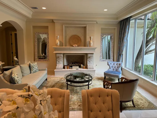 a living room with furniture fireplace and a large window