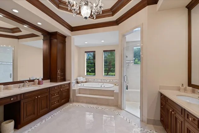 a spacious bathroom with a tub double vanity and a mirror