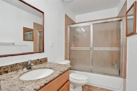 a bathroom with a granite countertop sink toilet and shower