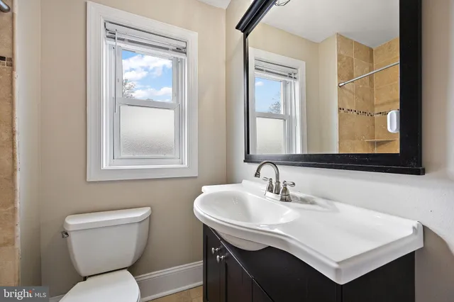 a bathroom with a toilet a sink and mirror