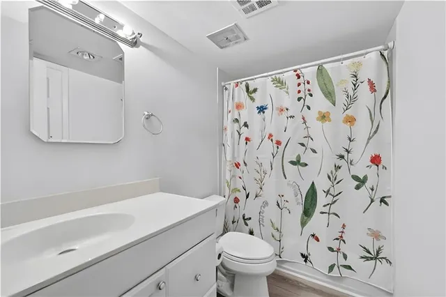 a bathroom with a toilet and a shower curtain