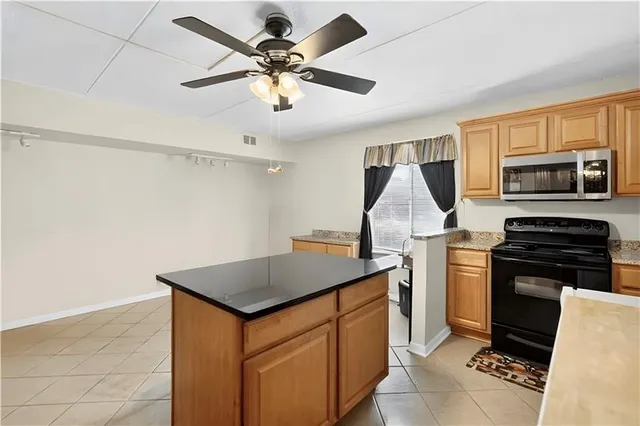 a kitchen with stainless steel appliances granite countertop a sink a stove and a refrigerator
