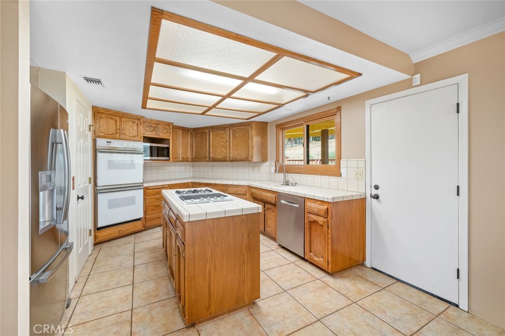 9170 Santa Lucia Road Atascadero, CA 93422 - Photo 11 of 60 a kitchen with granite countertop a sink and a refrigerator