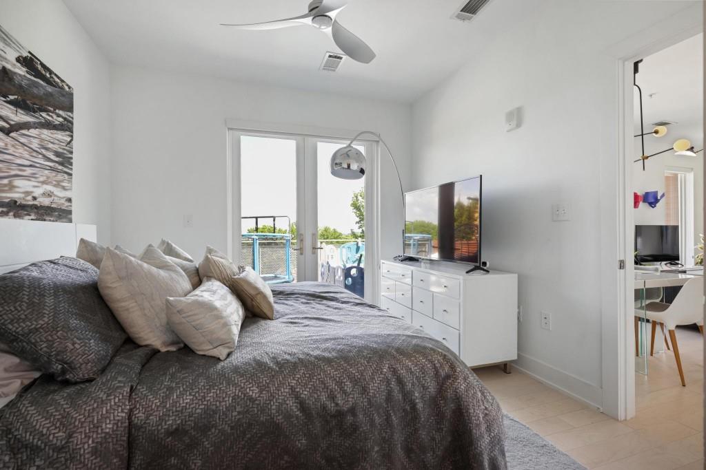 775 Juniper Street Northeast, Unit 602 Atlanta, GA 30308 - Photo 16 of 40 a bedroom with a bed and a flat screen tv