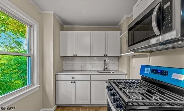 a kitchen with white cabinets and a stove top oven