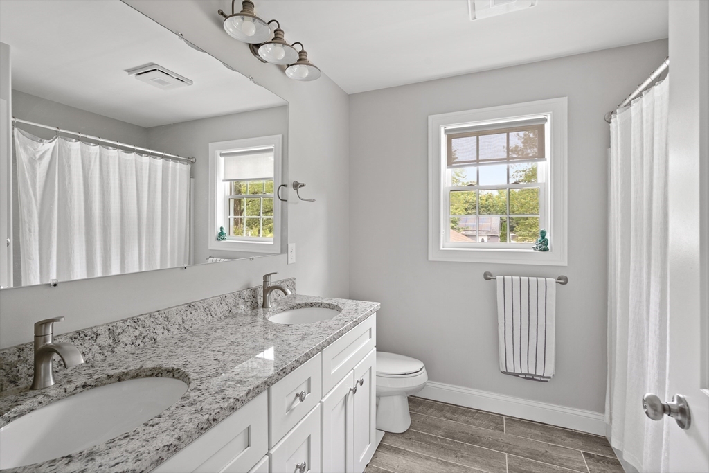 237 Glendale Road Northampton, MA 01062 - Photo 23 of 42 a bathroom with a granite countertop sink a toilet and a window