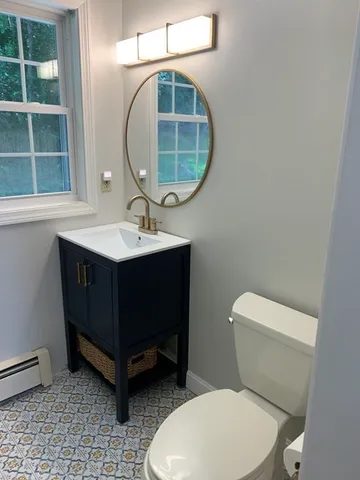 a bathroom with a toilet a sink and mirror