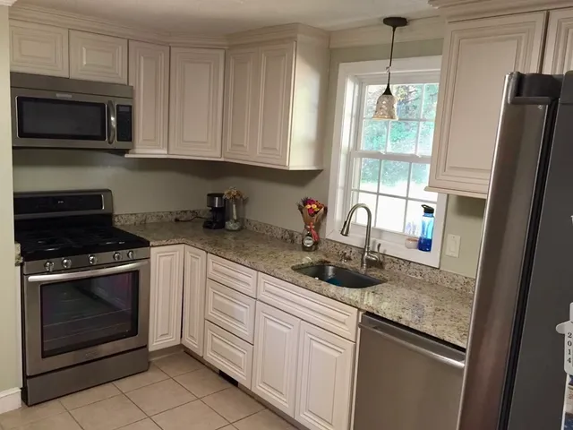 a kitchen with stainless steel appliances granite countertop a stove a microwave and a refrigerator