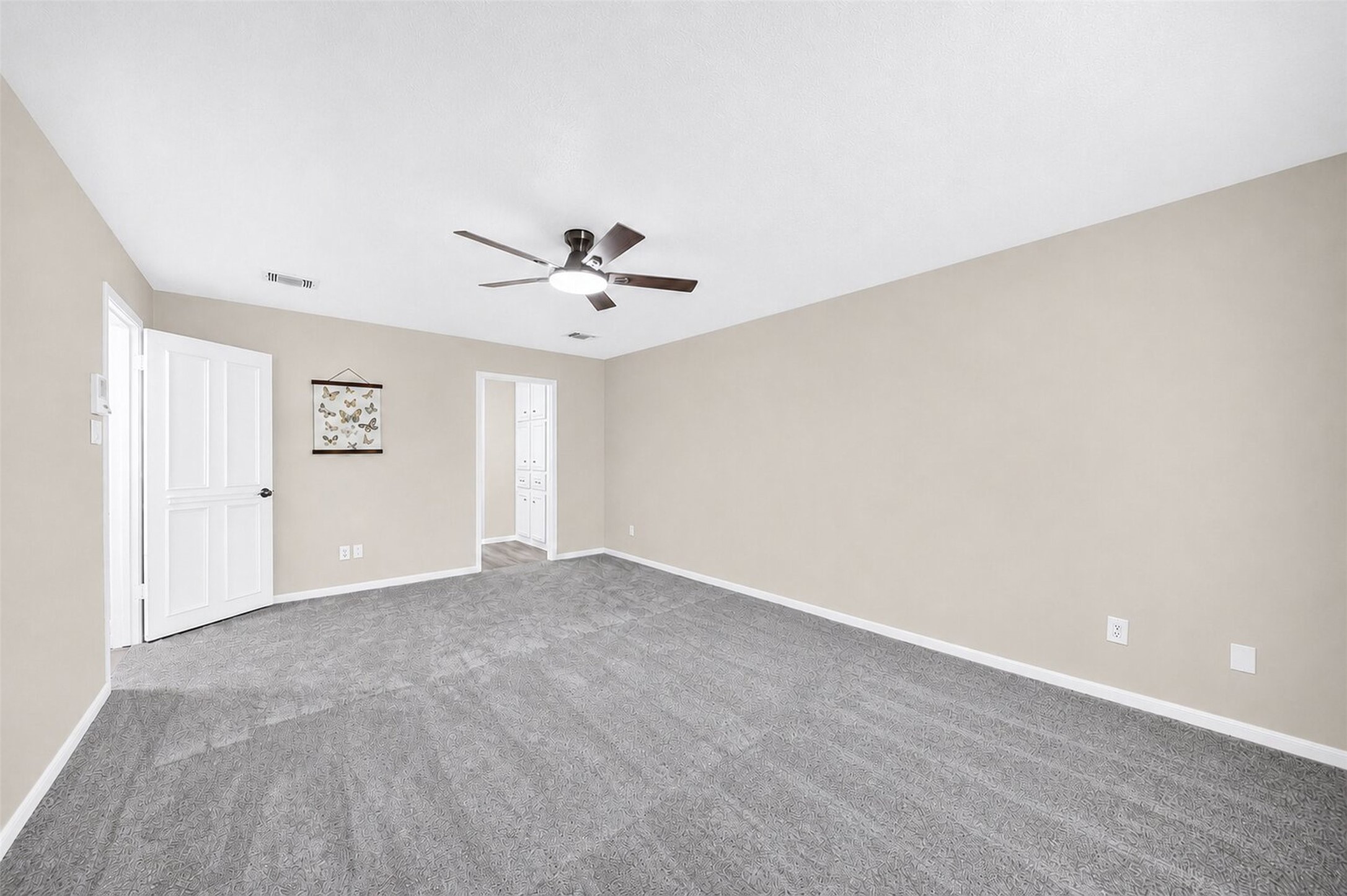 6507 Spring Leaf Drive Spring, TX 77379 - Photo 18 of 50 Spacious primary bedroom located on the first floor, with new plush carpeting, a modern ceiling fan, and direct access to the en-suite bath.