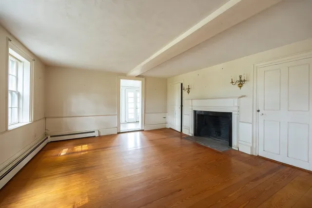 an empty room with windows and fireplace