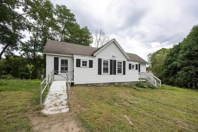 a view of a house with a yard and sitting area