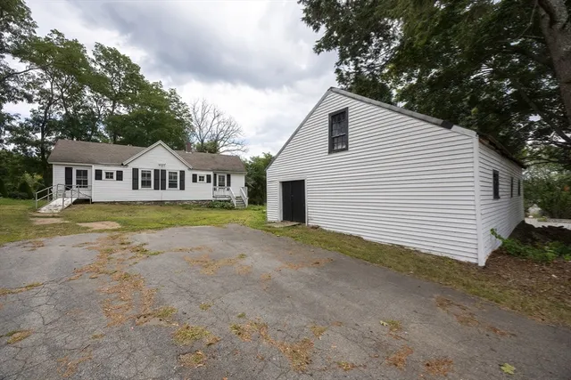 a front view of a house with a garden and trees