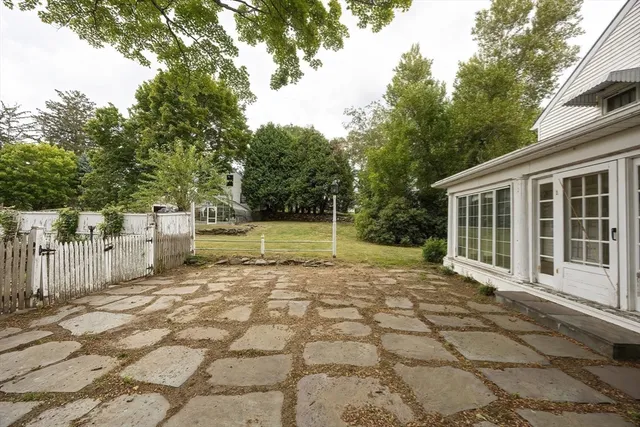a view of a house with backyard and a trees