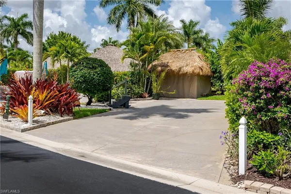 a street view with flower plants and palm trees