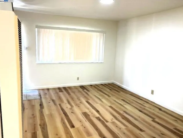 a view of a room with wooden floor and a window