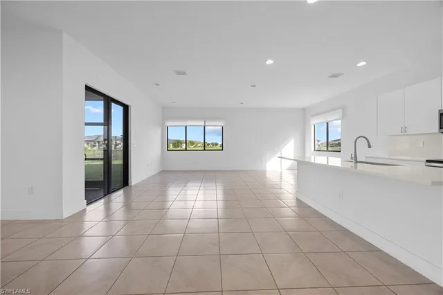 a view of a kitchen with furniture and an empty room