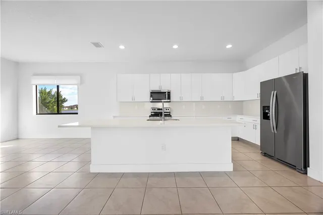 a view of kitchen with stainless steel appliances cabinets