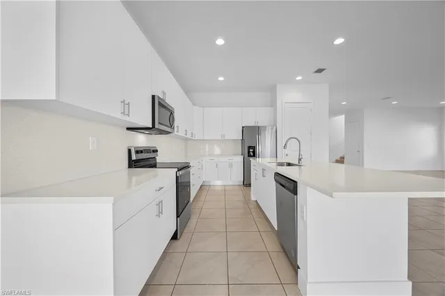 a large kitchen with stainless steel appliances lots of counter top space