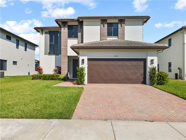 a front view of a house with a yard and garage