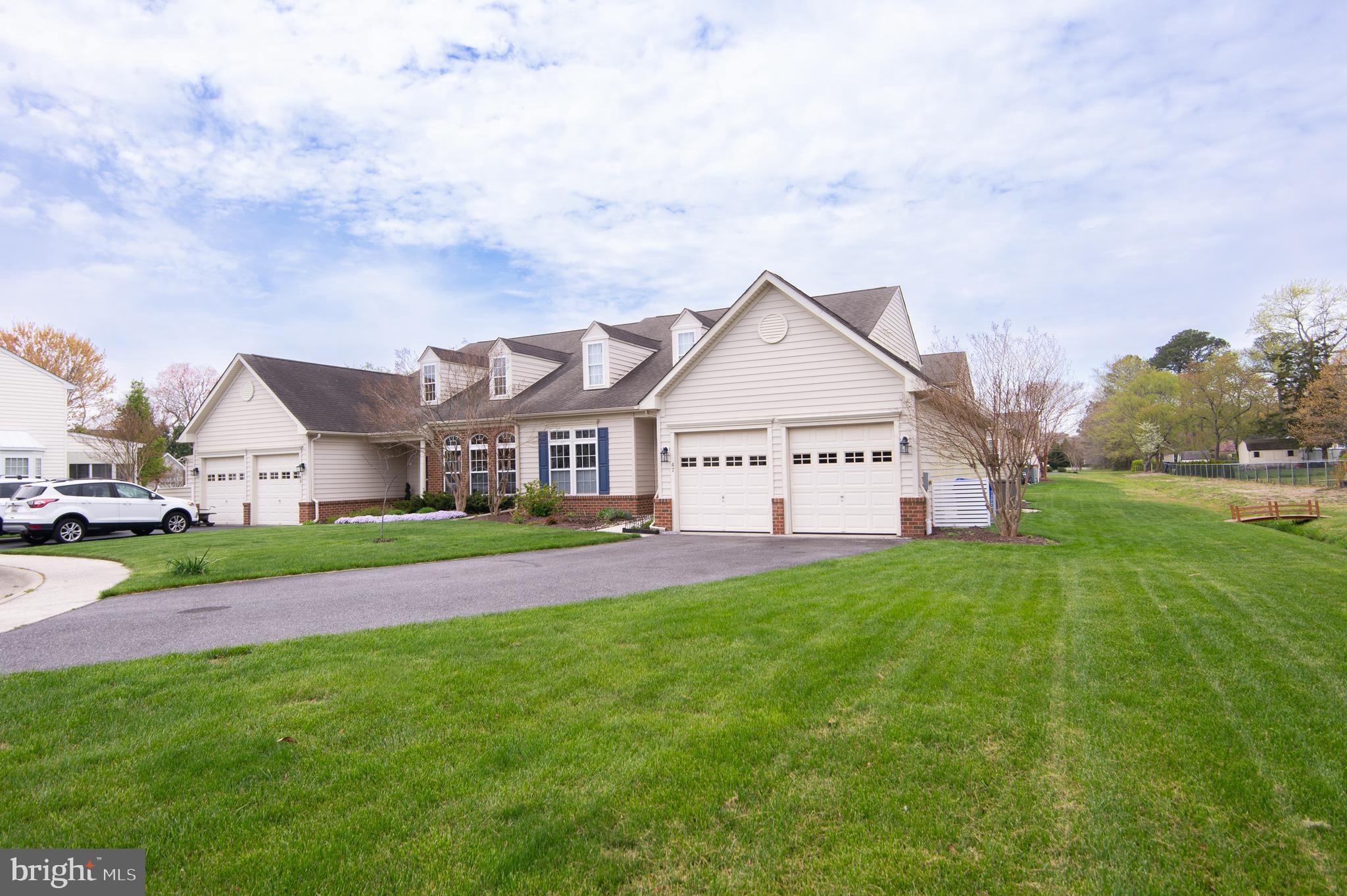 a view of a house with a big yard plants and large trees