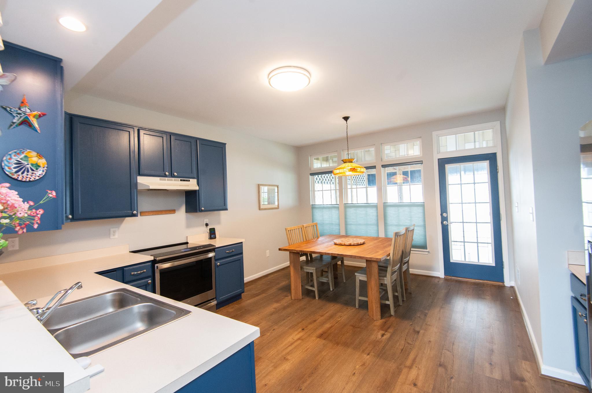 47 Brighton Street Ocean View, DE 19970 - Photo 6 of 44 a kitchen with stainless steel appliances granite countertop a stove a refrigerator a sink a dining table and chairs with wooden floor