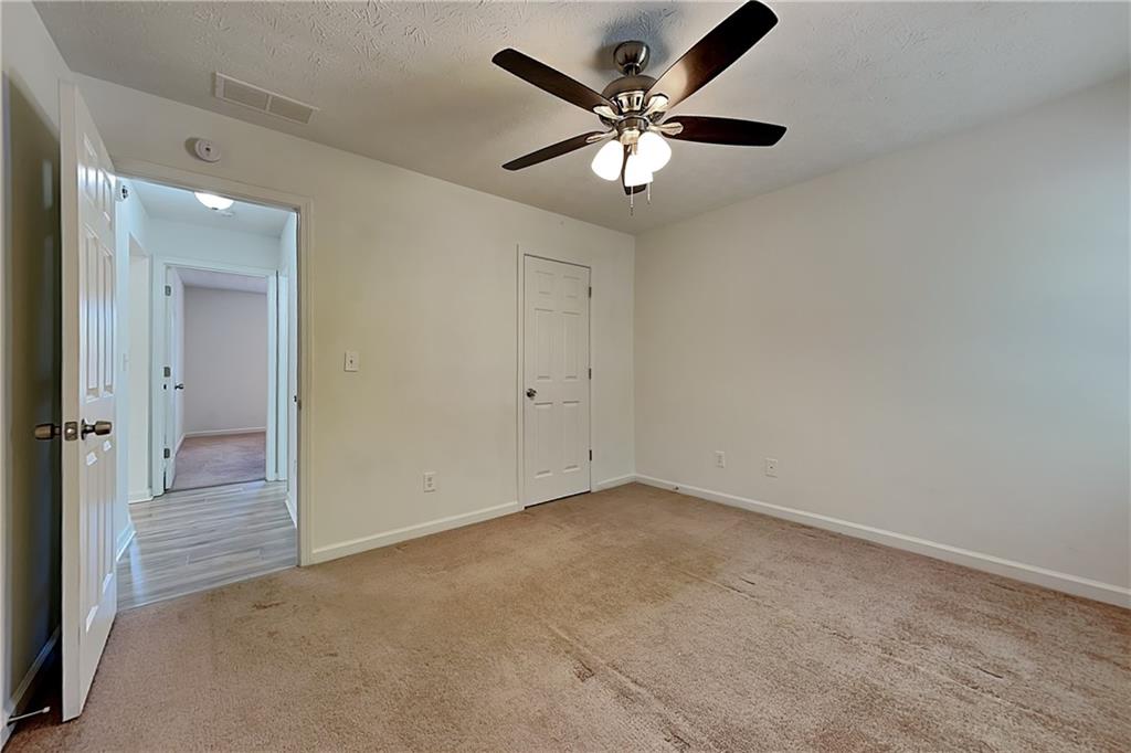 4206 Shoreside Circle Southwest Snellville, GA 30039 - Photo 13 of 20 an empty room with a chandelier fan and windows