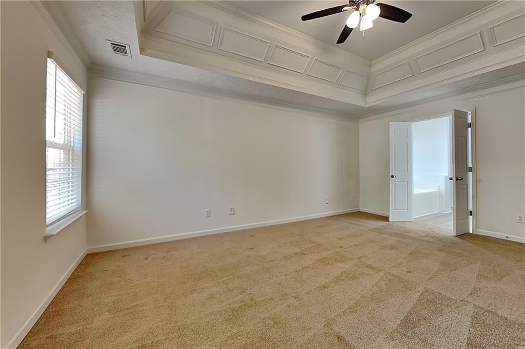 4206 Shoreside Circle Southwest Snellville, GA 30039 - Photo 8 of 20 an empty room with a chandelier fan and windows