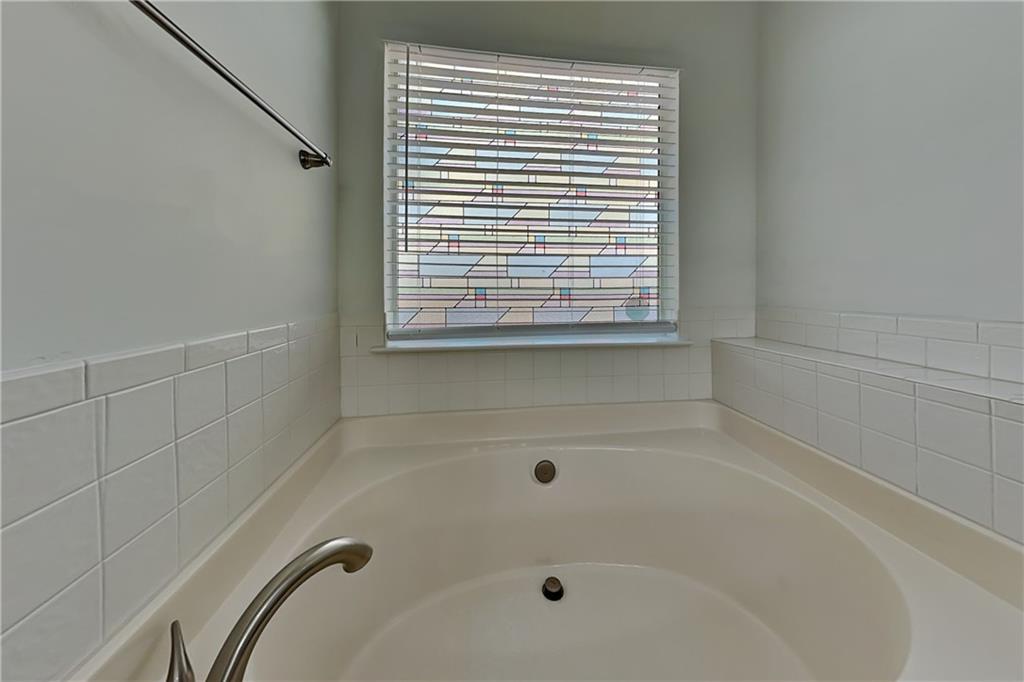4206 Shoreside Circle Southwest Snellville, GA 30039 - Photo 10 of 20 a bathroom with a tub and a window